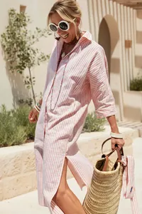 Close-up of a pink and white vertical striped shirt dress with a casual split hem