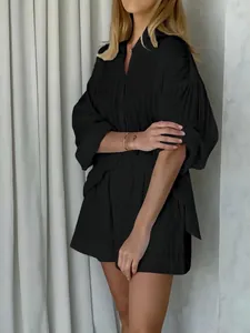 Close-up view of a chic black pleated two-piece set featuring puff sleeves and shorts