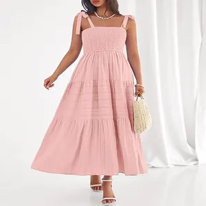 Détail d'une robe longue rose à plusieurs niveaux avec bustier froncé et bretelles