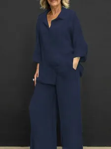 Vista completa di un set camicia a maniche lunghe e pantaloni a gamba larga blu notte.