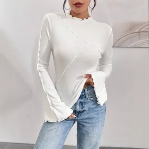 Elegante top bianco asimmetrico a coste con collo alto e maniche a campana con volant