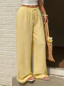 Détail du pantalon large jaune élégant avec une taille élastique et un cordon de serrage