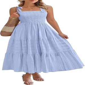 Détail d'une robe bleu clair à étages avec corsage froncé et bretelles à nouer aux épaules