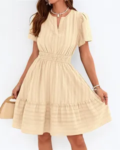 Gros plan sur robe beige à col en V, manches bouffantes, jupe à volants et texture