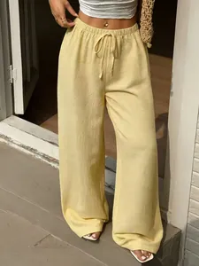 Vue détaillée d'un pantalon large jaune à taille haute avec cordon de serrage élastique.