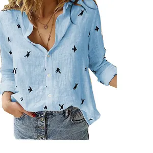 Close-up detail of women's casual loose light blue linen shirt with black bird pattern