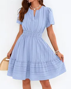 Détail d'une robe bleu clair à col en V avec manches bouffantes et jupe à volants