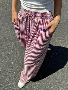 Detaillierte Nahaufnahme einer gestreiften Damen-Weithose mit Kordelzug und Taschen.