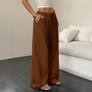 Casual women's brown textured wide-leg trousers featuring a drawstring waist and pockets.