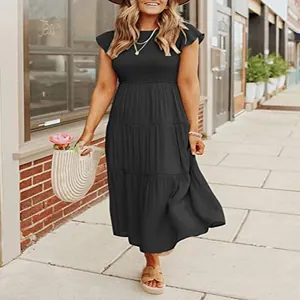 Close-up detail of black tiered maxi dress with flutter sleeves and smocked waist design