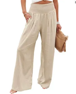 Detailed view of women's smocked waist wide-leg linen pants in beige