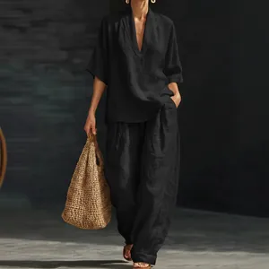 Ensemble deux pièces élégant pour femme, haut noir à col en V et pantalon large à poches.
