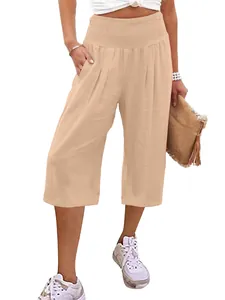 Dettaglio della vita alta a nido d'ape e delle pieghe sui pantaloni capri beige