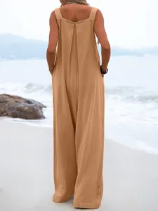 Detailed back view of a stylish apricot linen summer jumpsuit with wide legs on the beach