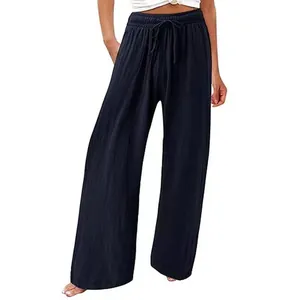 Gros plan détaillé d'un pantalon large en lin bleu marine pour femme avec cordon de serrage.