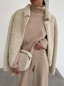 Detail view of beige knitted turtleneck and wide-leg pants set with a cozy fleece jacket