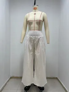 Detailed view of white cotton casual pants with a smocked waistband on a mannequin