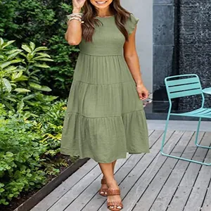 Olive green smocked tiered midi dress with ruffled fly sleeves in outdoor patio