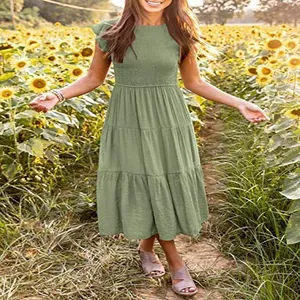 Elegant sage green flutter sleeve smocked tiered midi dress in a sunflower field setting