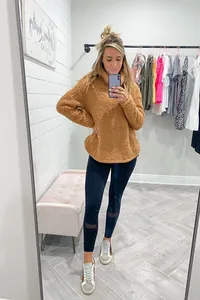 Άνετο καφέ χνουδωτό ζιβάγκο fleece πουλόβερ σε ένα κομψό selfie καθρέφτη μπουτίκ