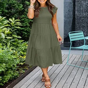 Elegant olive green tiered midi dress with fly sleeves in an outdoor garden setting