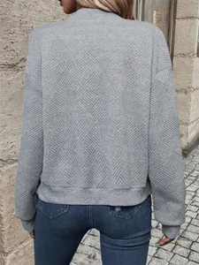 Vista posteriore di una giacca grigia da donna con cerniera e trama geometrica moda