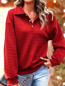 Close-up of women's red quilted sweatshirt with polo collar and button detail.