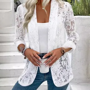 Dettaglio di un elegante cardigan in pizzo bianco indossato da una modella all'aperto