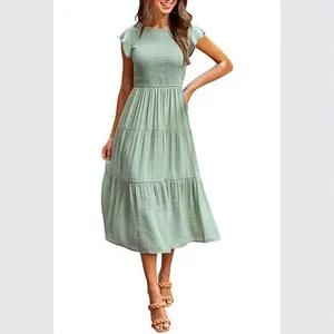 Elegantes salbeigrünes Kleid mit Smok-Mieder, Stufenrock und flatternden Ärmeln in Midi-Länge.