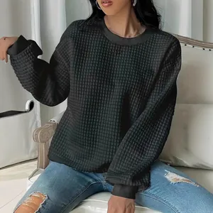 Sweat-shirt matelassé noir à col rond pour femme, haut texturé à la mode pour le printemps.