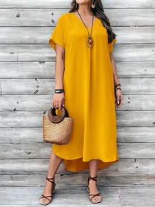 Full view of a vibrant yellow V-neck casual maxi dress with stylish accessories