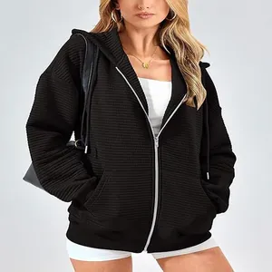 Detailed view of black ribbed zip-up hoodie featuring textured fabric and side pockets