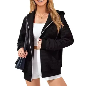 Stylish women's black zip-up hoodie with ribbed texture and convenient front pockets.