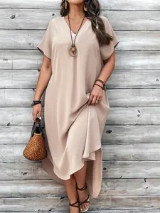 A loose fitting V-neck beige midi dress featuring a high-low hem in a casual chic style