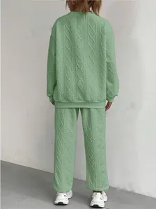 Vista posteriore di un completo da donna verde chiaro in maglia a trecce, top e pantaloni