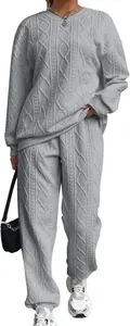 Dettaglio del set due pezzi grigio da donna in maglia a trecce, maglione e pantaloni