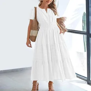 Full body view of a model wearing a white tiered maxi dress in a bright sunlit room