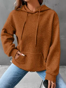 Casual women's waffle knit long sleeve hoodie in rust orange with kangaroo pocket