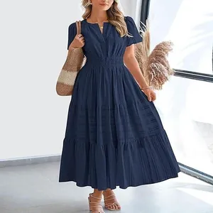 Navy blue V-neck tiered maxi dress with short puff sleeves in a stylish indoor setting