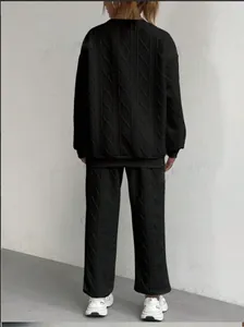 Vista posteriore di un completo due pezzi nero in maglia a trecce da donna, top e pantaloni