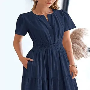 Close-up view of navy blue V-neck tiered dress with puff sleeves and elastic waist belt