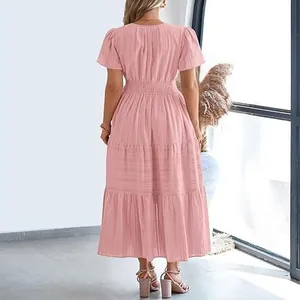 Back view of a pink tiered maxi dress with puffed sleeves in a bright indoor setting