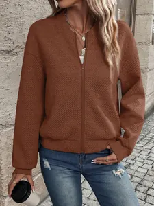 Dettaglio di una giacca marrone testurizzata con cerniera e motivo trapuntato per donna