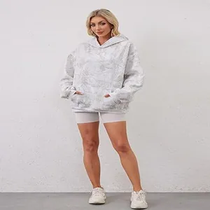 Full length view of a woman wearing an oversized white marble print hoodie with front pocket.