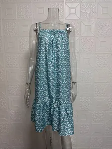 Close-up of a teal floral spaghetti strap summer dress with ruffled hem on a mannequin.