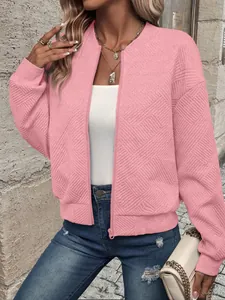 Close-up of pink zip-up bomber jacket with textured diamond pattern fabric.