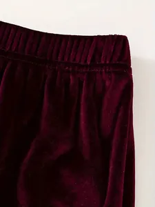 Λεπτομέρεια μπορντό βελούδινου παντελονιού με ελαστική μέση και ραβδωτή υφή υφάσματος