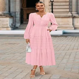 Elegant pink V-neck tiered midi dress with long puff sleeves shown in a street setting