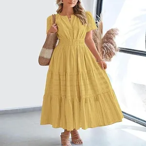 Detail of a yellow tiered V-neck maxi dress with short puff sleeves on a model.