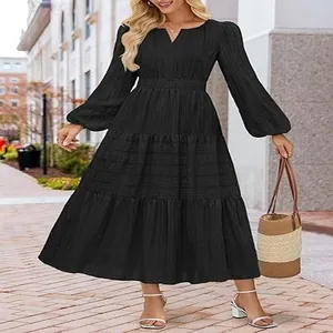 Detail of V-neck tiered puff sleeve midi dress with smocked waist and textured fabric